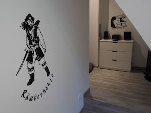 A wall with a black and white sticker of a character and the text 'Räuberhöhle'. - Ferienhaus in Rerik mit Garten (Rerik)