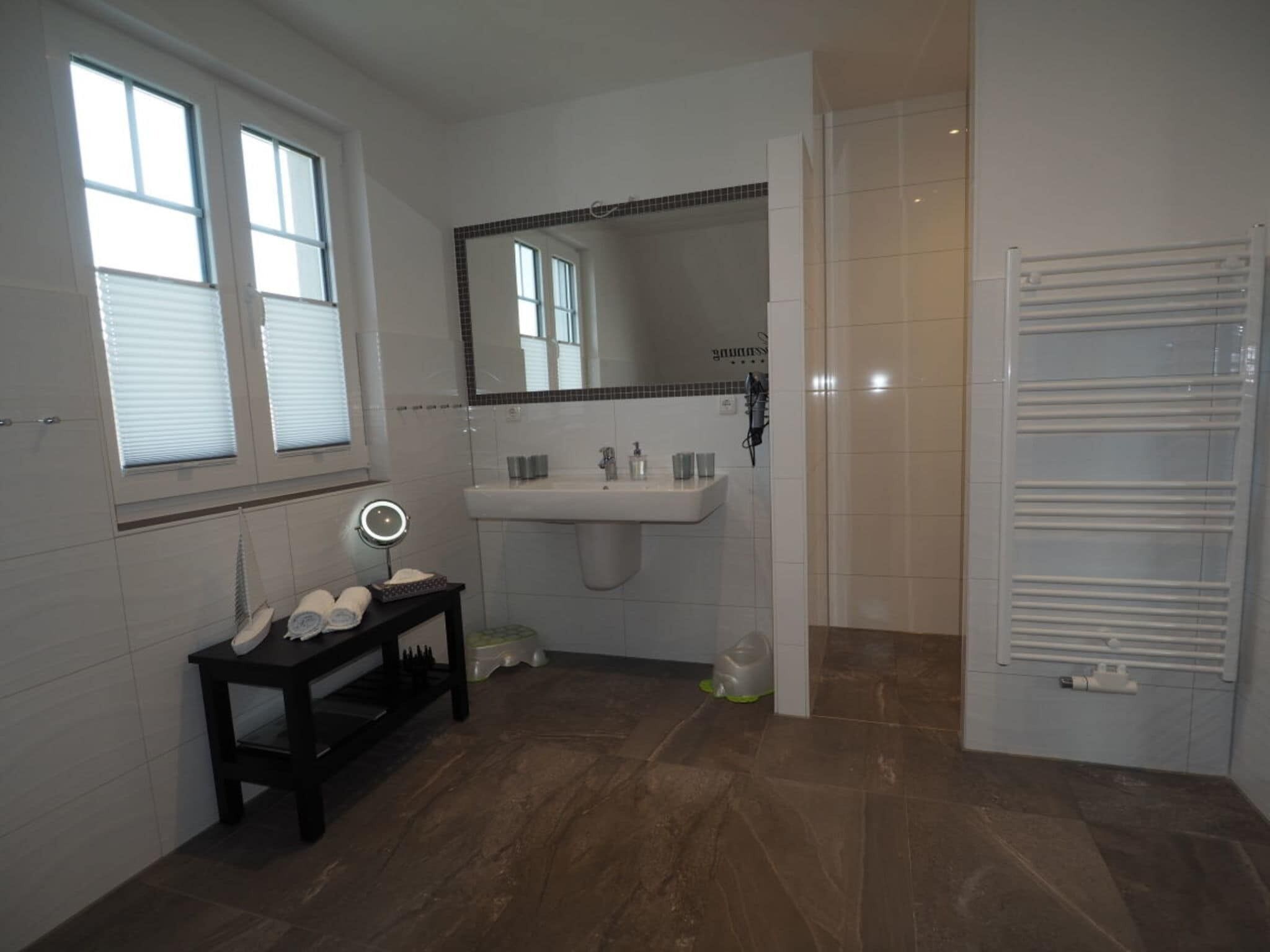 Une salle de bain équipée d’un meuble-lavabo, d’un miroir, d’un évier et d’un porte-serviettes.
