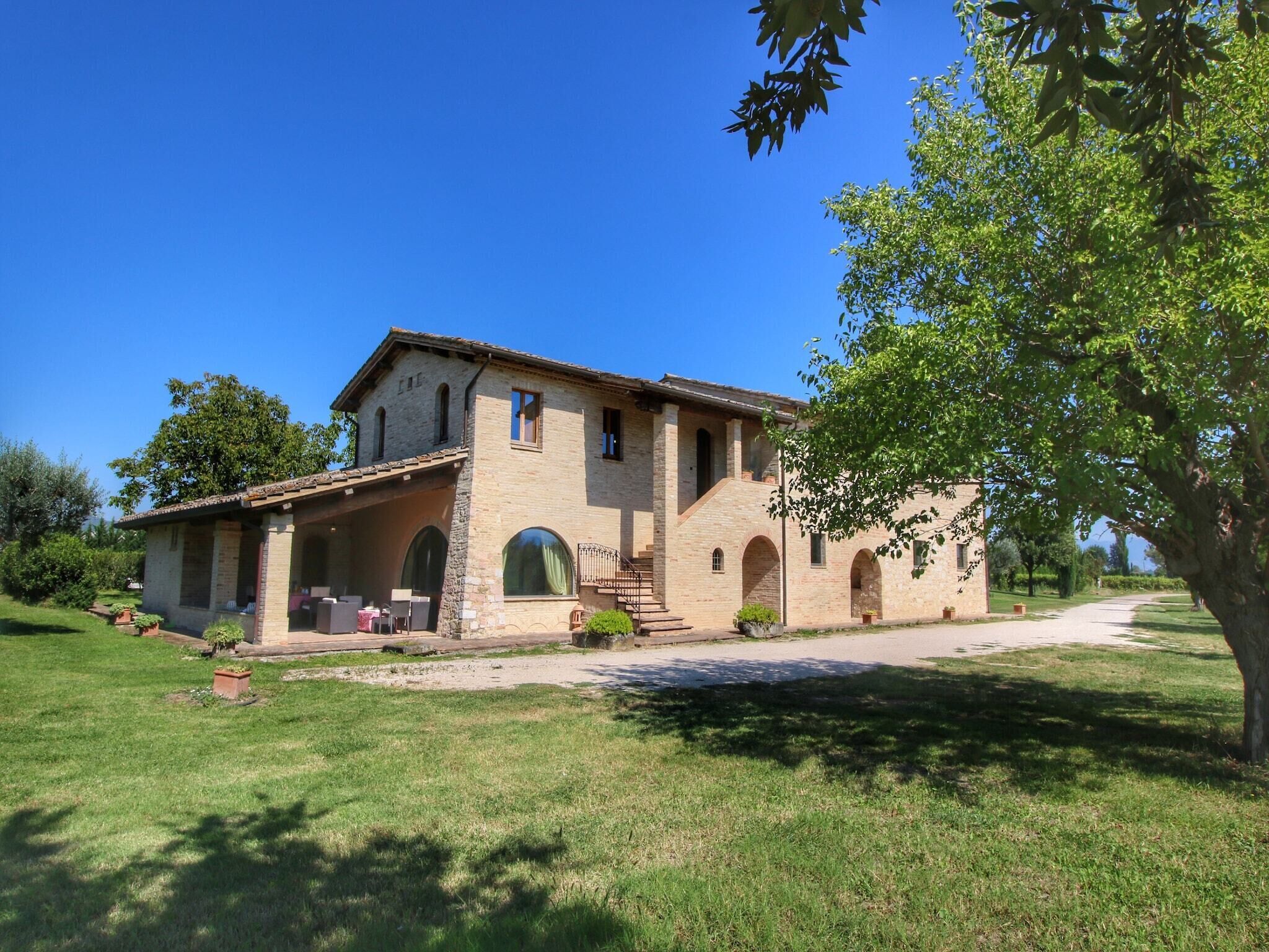 A two-story stone building with a covered patio and a large arched doorway.
