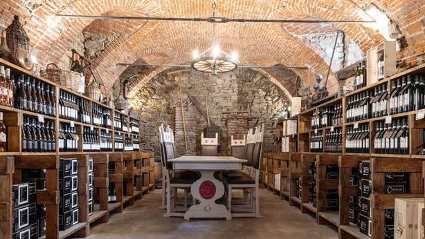 Une cave à vin avec des étagères en bois et une table centrale.