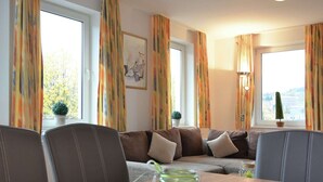A cozy living room with a sofa, chairs, a table with a glass jar, and a lamp. - Modernes Apartment in Willingen mit Balkon (Willingen)