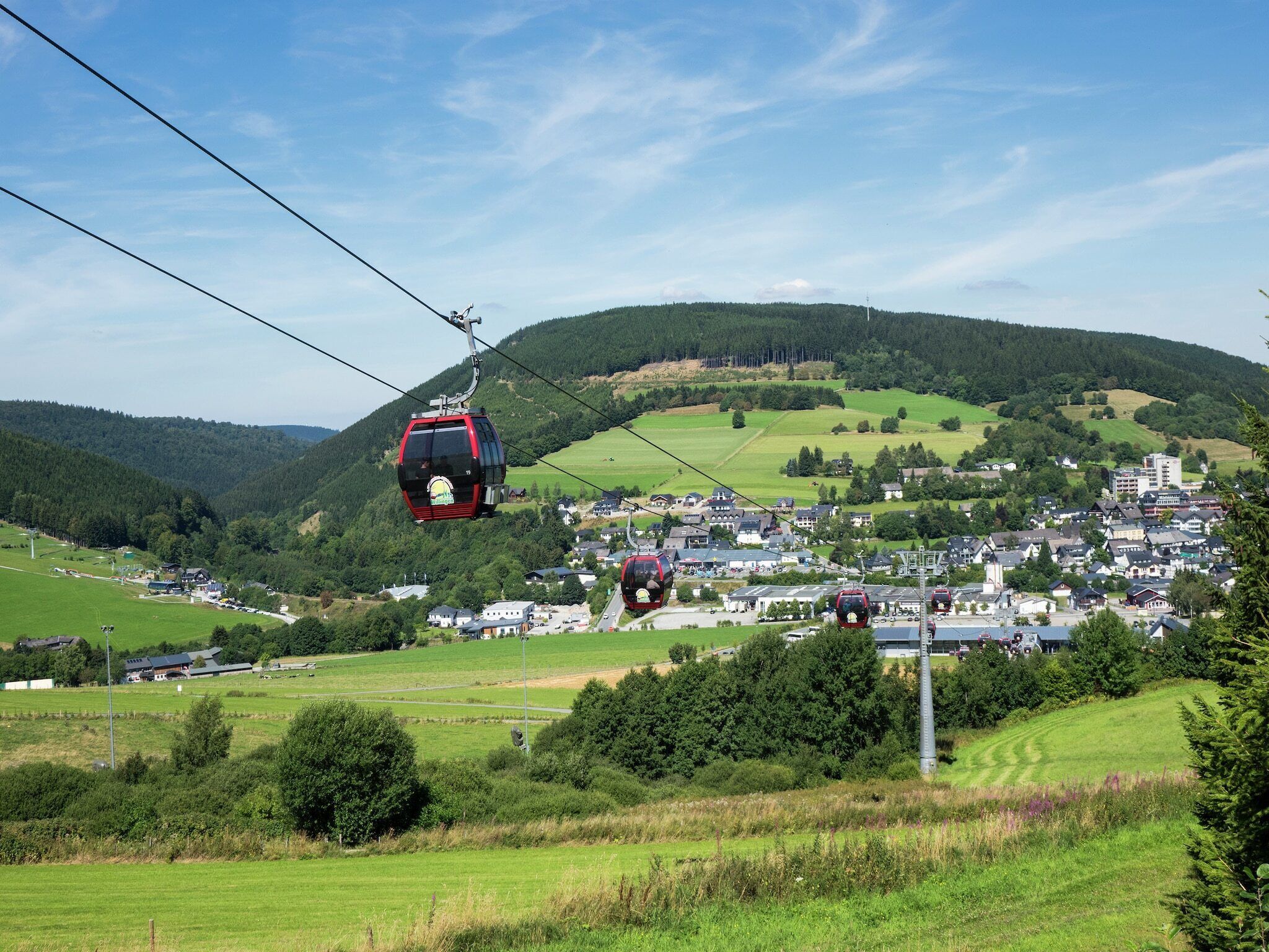 Eine Seilbahn mit einer Stadt im Hintergrund.