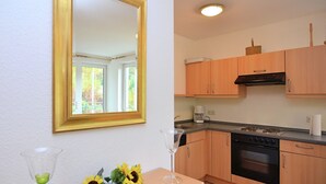 Eine kleine Küche mit Holzausstattung, einem Backofen und einer Kaffeemaschine.