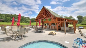 A poolside area with a wooden gazebo, outdoor seating, and a view of the surrounding landscape. - In-Town Smoky Mountain Views • No Steep Roads • Fully fenced Area for Pets. (Sevierville)
