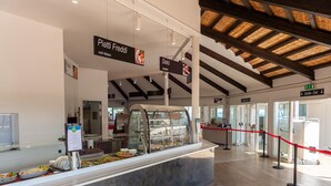 A buffet area with cold dishes, a deli section, and a clear exit sign.