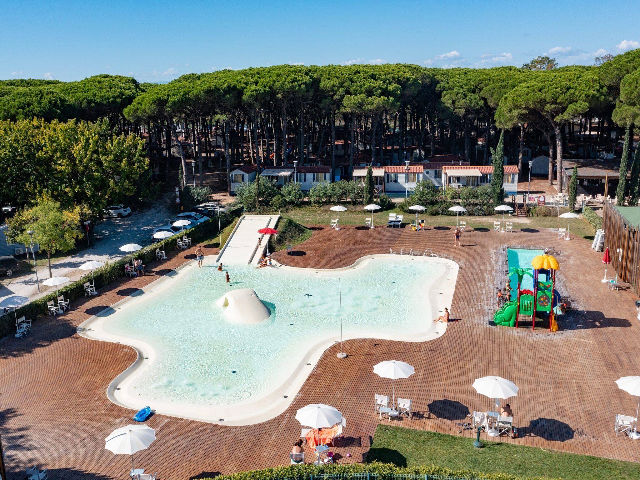 Ein Resort mit Schwimmbad, Liegestühlen und einer Wasserrutsche.