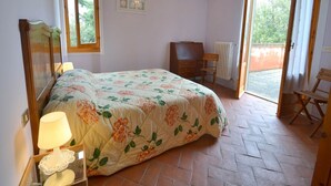 Une chambre à coucher comprenant un lit, un bureau, une chaise, un radiateur et une fenêtre.
