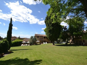 A courtyard with a lawn, outdoor seating, and buildings in the background.