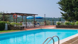 A swimming pool with a pergola, lounge chairs, and umbrellas. - Montaione Oasis: Shared Villa (Montaione)