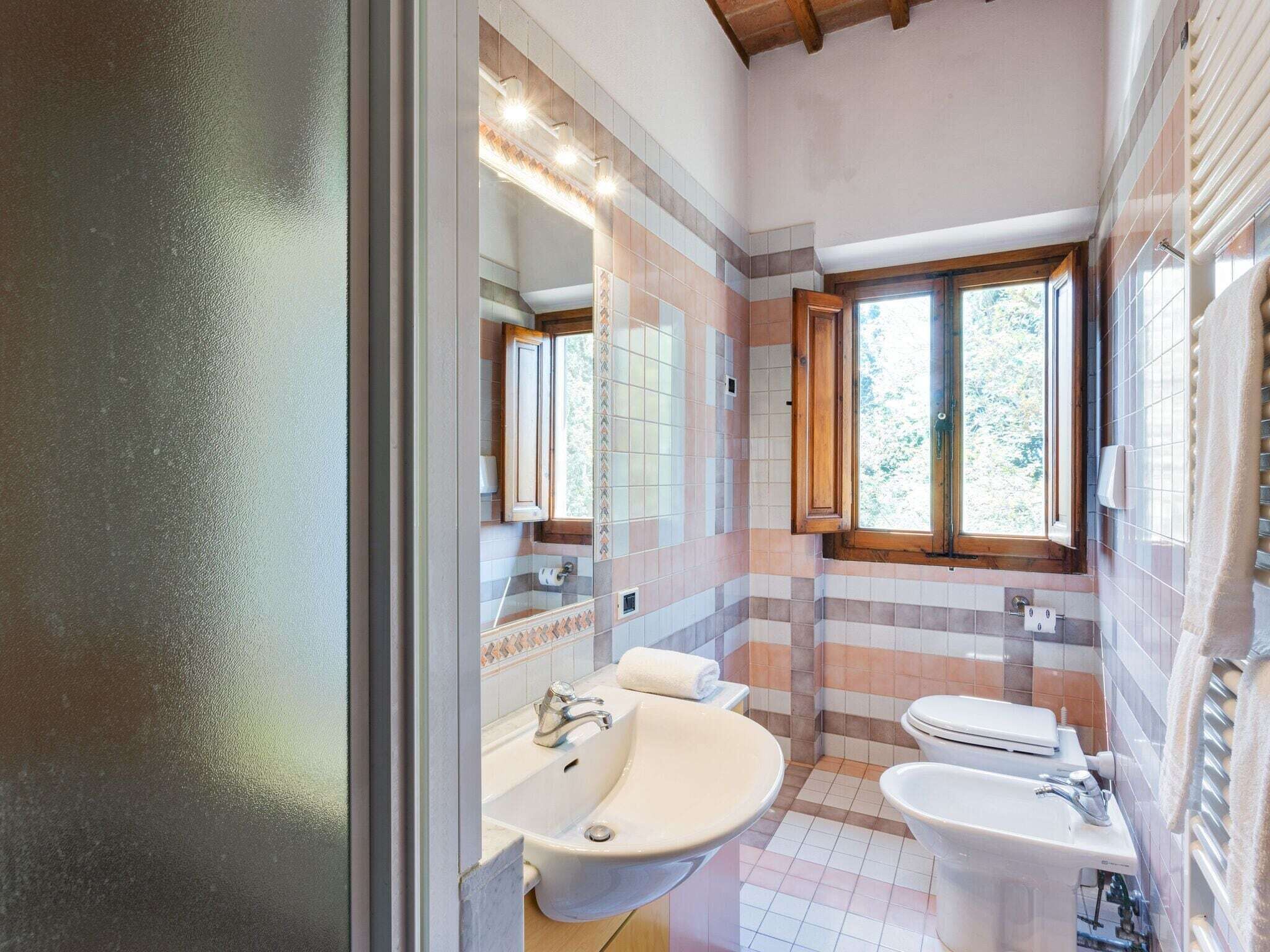 Baño con lavamanos, inodoro y ventana.