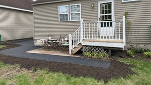 A residential house with a front porch, a small table and chairs, and a garden area. - Cozy 3 bedroom house (South Glens Falls)