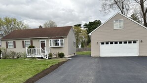 A residential driveway leading to a house with a garage. - Cozy 3 bedroom house (South Glens Falls)