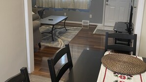 A dining area with a table, chairs, and a decorative table runner. There is a ceiling fan above and a door with a window in the background. - Cozy 3 bedroom house (South Glens Falls)
