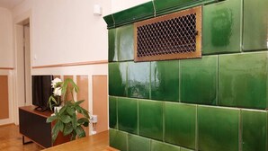 A room with a green tiled wall, a wooden table, and a plant.