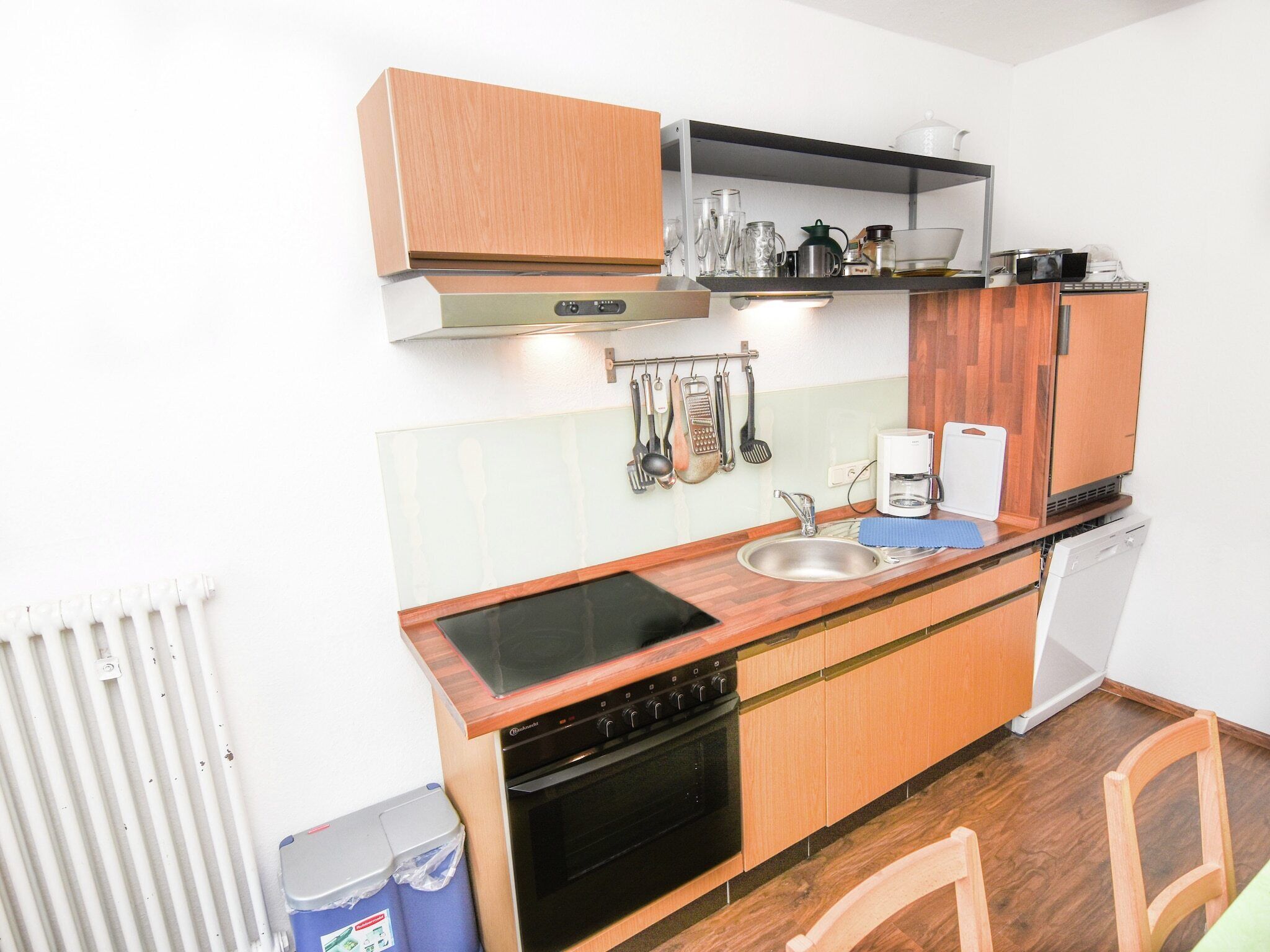 Une cuisine de taille réduite équipée d’une cuisinière, d’un évier et d’un four à micro-ondes.