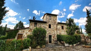A stone building with a small entrance and a window, surrounded by greenery. - Chianti Hillside Farmhouse (Radda in Chianti)