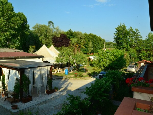 A courtyard with a gazebo, a tent, and a car parked nearby.
