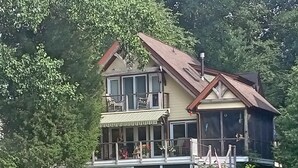 A two-story house with a balcony and a dock extending into a body of water. - GREENNEST is an ENVIRONMENTALLY FRIENDLY  Waterfront home close to Annapolis (Annapolis)