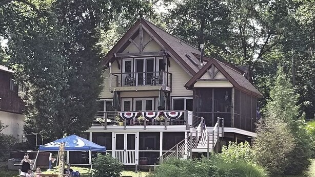 A large house with a balcony, a dock, and a small boat. - GREENNEST is an ENVIRONMENTALLY FRIENDLY  Waterfront home close to Annapolis (Annapolis)