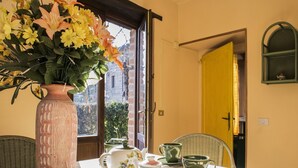 Une table à manger ornée d’un vase de fleurs, d’une théière, ainsi que de tasses et de soucoupes assorties.