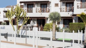 A white building with balconies and a cactus in the foreground. - Terrace Stay Close to Beaches (Playa Blanca)