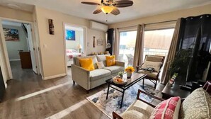 A living room with a sofa, armchairs, a coffee table, and a ceiling fan. - 3 Minute walk to famous Waikiki beach 100% legal with Free Parking  (Honolulu)