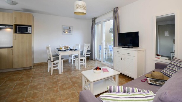 Een functionele leefruimte met kitchenette, eethoek en zithoek.