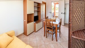 A compact living space with a kitchenette, a dining area, and a sofa.