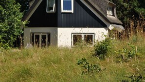 Et hus med et stejlt tag, to vinduer og en skorsten.