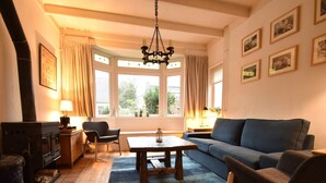 Un salon chaleureux avec une cheminée, un canapé, une table basse et un lustre.