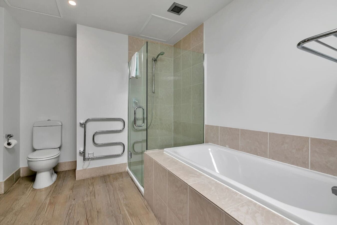 Ein modernes Badezimmer mit Toilette, Duschkabine und Badewanne.
