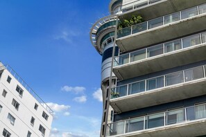 A multi-story building with balconies, large windows, and a curved architectural feature.