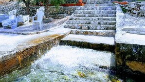 A stone staircase leading to a building with a white facade, surrounded by greenery and a small water feature. - Apartments Marko - Two Bedroom Apartment with Terrace with Sea View (Okrug Donji)