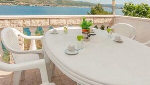 A round table with white chairs on a balcony overlooking a coastal landscape. - Apartments Marko - Two Bedroom Apartment with Terrace with Sea View (Okrug Donji)