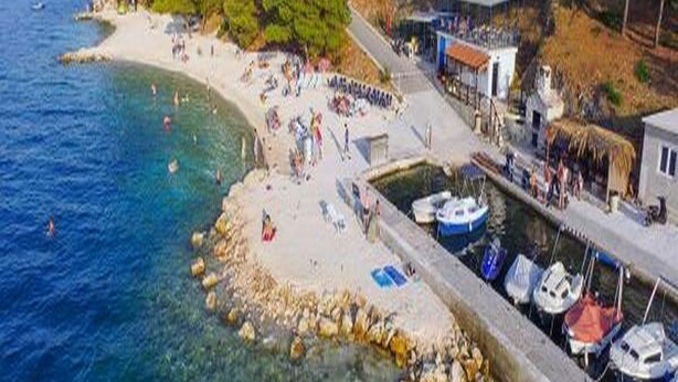 A coastal beach with clear waters, a rocky shoreline, and several boats docked at a pier. - Apartments Marko - Two Bedroom Apartment with Terrace with Sea View (Okrug Donji)