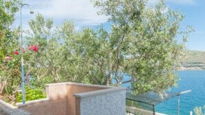 A coastal terrace with a stone balustrade, a clear view of the sea, and lush greenery. - Apartments Marko - Two Bedroom Apartment with Terrace with Sea View (Okrug Donji)