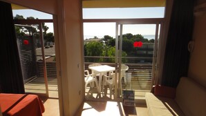 A room with a sliding glass door leading to a balcony with a table and chairs.