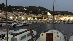 Un port de plaisance avec des bateaux amarrés, une passerelle en bois et des bâtiments en arrière-plan.