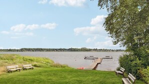 A lakeside view with a wooden dock extending into the water, surrounded by grassy areas and benches. - Gorgeous home in Sunds with kitchen (Sunds)