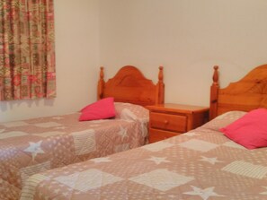 Two single beds with patterned bedding and wooden headboards.