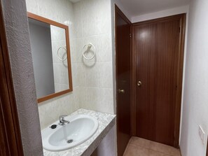 Bathroom features a sink, mirror, and tiled walls.