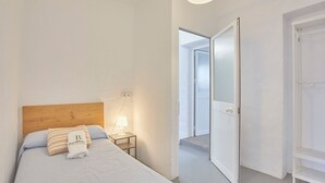 A bedroom with a wooden headboard, a bed with white bedding, a bedside lamp, and a towel with text. - Cortijo de Liche Arcos de la Frontera by Ruralidays (Cádiz)