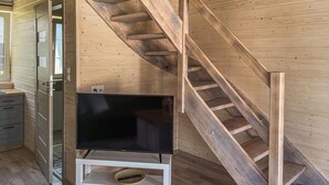 A wooden interior with a staircase, a television on a stand, and a door leading to another room. - 2 bedroom gorgeous home in Debki (Debki)