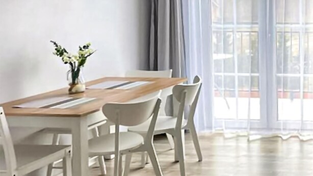 A dining area with a wooden table, white chairs, and a vase of flowers. - Awesome apartment in Karwia (Karwia)
