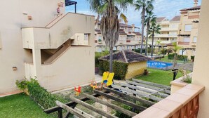 A residential area with a swimming pool, a small garden, and a wooden play structure.