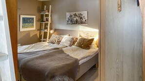 A bedroom with a bed, pillows, a bedside table, a shelf with books, and a framed picture on the wall. - Lovely home in Taberg with kitchen (Taberg)