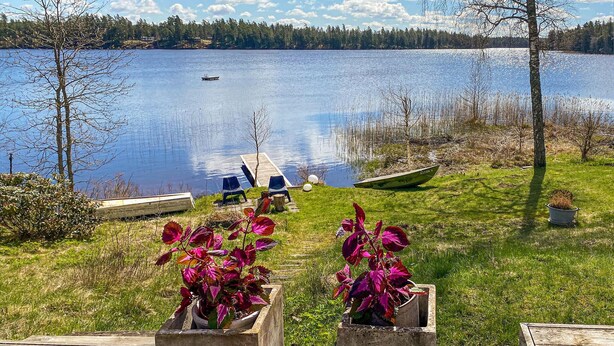 A lakeside view with a dock, chairs, and a boat named 'ENTER 1'. - Lovely home in Taberg with kitchen (Taberg)