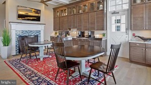 A modern kitchen with a fireplace, dining area, and built-in cabinets.