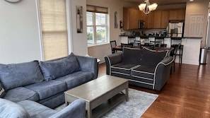 Ein Wohnzimmer mit einer Couch, einem Couchtisch und einem Essbereich mit Stühlen und einem Tisch.