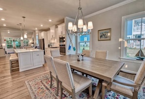 A spacious kitchen with a central island, pendant lighting, and a view of the outside.